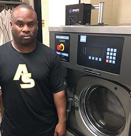 Alabama State University Equipment Manager standing next to a Sports laundry Systems Washer-extractor